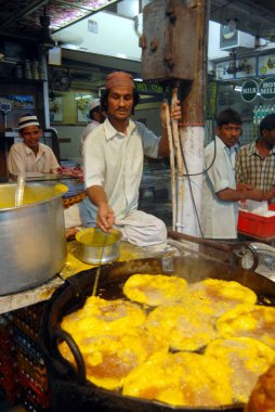 Bir gıda tedarikçisi, Müslümanlar Pydhonie, Bombay 'daki Khatri Mescidi' nde ramazan orucunu kırarken yenilebilir yiyecekler hazırlıyor. Mumbai, Maharashtra, Hindistan 