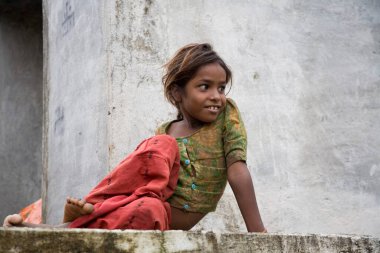 Güney Asyalı 8 yaşındaki kız oturuyor, Bheel kabilesi, Delwara köyü, Udaipur, Rajasthan, Hindistan 