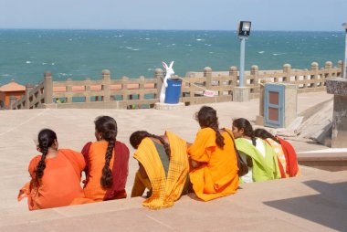 Vivekananda Kolajı 'nda Bengal Körfezi' nin birleşmesini izleyen renkli elbiseli kızlar; Kanyakumari; Tamil Nadu; Hindistan