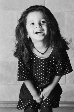 Evde poz veren sevimli Hintli kızın siyah beyaz portresi.