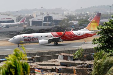 Air India flight preparing to take off from Sahar Airport or Chatrapati Shivaji International Airport foreground slums around airport in Bombay Mumbai, Maharashtra, India  clipart