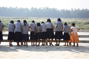 Adi Shankarachaya Tapınağı, Kaldi, Kerala, Hindistan 'da Poorna nehrinin kıyısında mavi gömlek ve etek giyen liseli kızlar. 