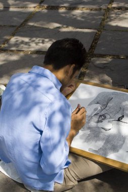 Sanatçı kalem ve siyah mürekkeple çizim yapıyor, Hindistan  