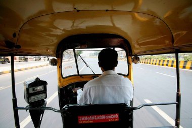 Bombay Mumbai, Maharashtra, Hindistan 'da triportör kullanan bir triportör şoförü. 