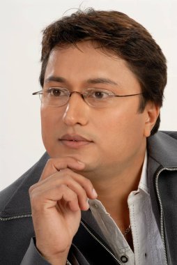 Güney Asyalı, gözlüklü, beyaz stüdyo arka planında düşünme modunda bir adam.