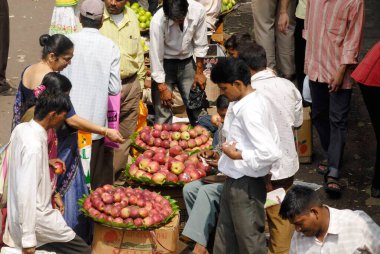 Yol kenarındaki işportacılardan elma alan erkekler ve kadınlar, Dadar, Bombay Mumbai, Maharashtra, Hindistan 'da Ganapati festivali kalabalığı. 