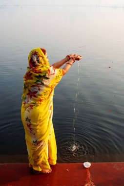 Yamuna 'da yükselen güneşe itiraz eden kadın; Mathura; Uttar Pradesh; Hindistan