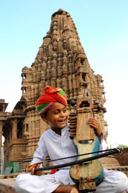Boy playing sarangi ; Deval ; Mandore ; Jodhpur ; Rajasthan ; India MR769L clipart