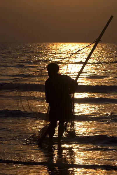 stock image Fisherman pulling fishing net in sunset ; Arabian sea at Kalamb beach ; Bassein now Vasai ; district Thane ; Maharashtra ; India