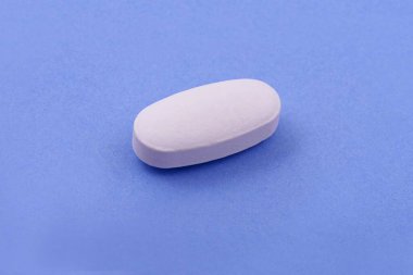 Mavi arka planda beyaz ilaç tableti