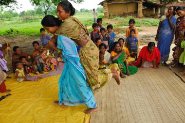 Ho kabilelerinden kadınlar sırtına biniyor ve tıbbi bilgileri paylaşıyorlar, Chakradharpur, Jharkhand, Hindistan   