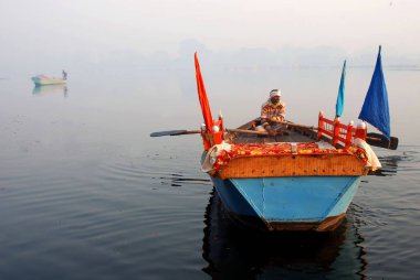 Yamuna, Mathura, Uttar Pradesh, Hindistan 'da sisli renkli bir tekne. 