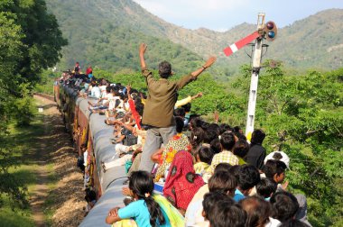 İnsanlar trenin çatısında seyahat ederken risk alıyorlar, Gram ghat, Marwar Junction, Rajasthan, Hindistan 