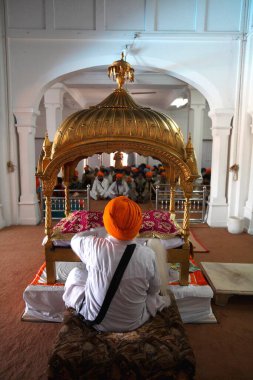 Sih din adamı dalgaları Anandpur 'daki kutsal Guru Granth Sahib' in üstünden geçiyor. Sahib Gurudwara, Rupnagar, Punjab, Hindistan 