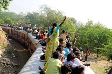 İnsanlar trenin çatısında seyahat ederken risk alıyorlar; Goram ghat; Marwar Junction; Rajasthan; Hindistan