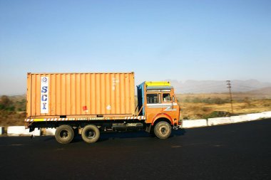 Endüstri, ulaşım, konteyner kamyonu yolda, mavi gökyüzüne karşı, ihracat, 3 numaralı ulusal otoyol, Mumbai Bombay Nasik Yolu, Maharashtra, Hindistan 