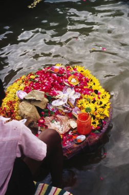 Su yüzeyinde çiçekler kovası, varanasi, uttar pradesh, Hindistan 