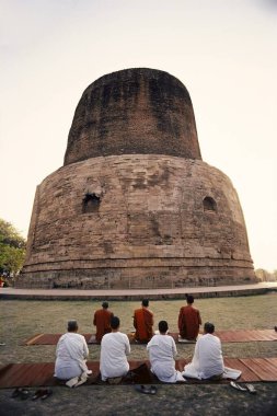 Buddhist monks bowing in prayer, Sarnath, Varanasi, Uttar Pradesh, India  clipart