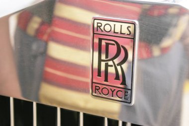 Rolls Royce arabasının çelik panelinde logo, Pune, Maharashtra, Hindistan 'daki renkli bekçi korsesi yansıması. 