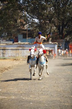 Nihang or Sikh warriors performing stunts, cultural events for 300th year celebrations of Consecration of perpetual Guru of Sikh Guru-Granth at Khalsa Sports ground in Nanded, Maharashtra, India 30-October-2008  clipart