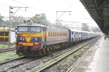 Thane tren istasyonundan ayrılan elektrikli lokomotif yolcusu Kushinagar ekspres treni; Maharashtra; Hindistan HAYIR