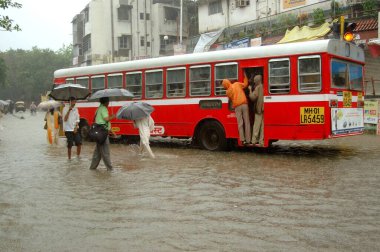 Haziran 2006 'da Bombay Mumbai, Maharashtra, Hindistan' da yoğun yağmurda insanlar otobüse biniyor. 