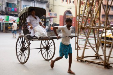 Kalküta 'daki yolcu sokağı sahnesiyle el arabası çeken adam şimdi Kolkata, Batı Bengal, Hindistan 
