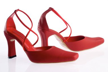 Beyaz arkaplanda yansıması olan kırmızı topuklu ayakkabılar. 