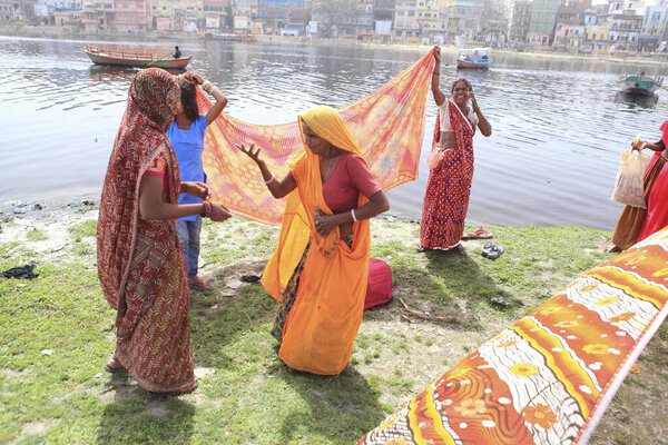 Women Drying saree on Yamuna river at Uttar Pradesh India 