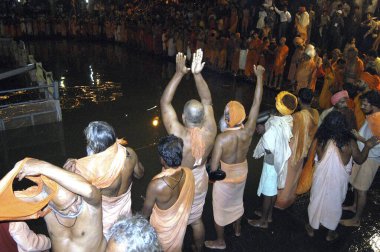 Sadhus, Hindistan, Maharashtra, Nasik yakınlarındaki Trimbakeshwar 'daki Kumbh Kela 2003' te kutsal bir dalış yapmadan önce pooja yapıyor.. 