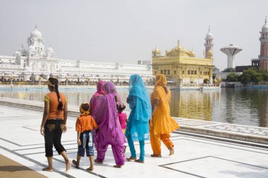 Sih kadınlar ve çocuklar kutsal havuzun yanında yürüyorlar, Swarn Mandir Altın Tapınağı, Amritsar, Punjab, Hindistan 