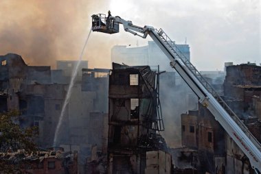 İtfaiyeciler Behrampada varoşlarında şnorkel kullanarak yangın söndürüyorlar; Bandra; Bombay Mumbai; Maharashtra; Hindistan 18-Haziran-2009