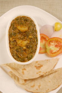 Hint yemeği Aaloo Methi sebzesi patates ve çeçen peynirli, roti ekmekli, domatesli ve soğanlı