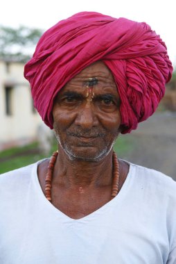 Kırsal kesimde kameraya bakan adam, Marathwada, Maharashtra, Hindistan  