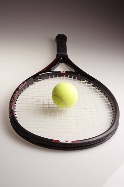 Beyaz arka planda raketi olan yeşil bir tenis topu.