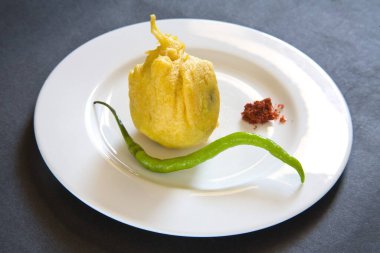 Hint fast food kızarmış batata patates vada ile kırmızı acı sos ve yeşil biberli siyah arka planda servis edilir.   