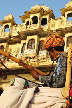 Heritage Building, Udaipur, Rajasthan, Hindistan 'ın önündeki folk müzisyeni.  