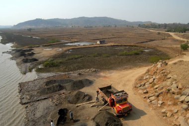 İşçiler dereden kumu alıp Uran, Raigad Bölgesi, Maharashtra, Hindistan yakınlarındaki bir kamyona yüklüyorlar. 