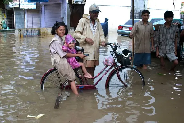 stock image Floods due to heavy rain, Monsoon, in Mumbai Bombay, Maharashtra, India, pictures shot on 27th july2005 in Mira road. Record 944mm rainfall in the city, Water logging in the residential colony, People walking in water, Indian girl on bicycle.