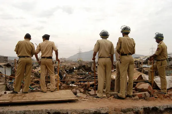 stock image Police constables keep watch to prevent any untoward incidents during the demolition of illegal slums on the Mankhurd Link Road in Bombay now Mumbai, Maharashtra, India 