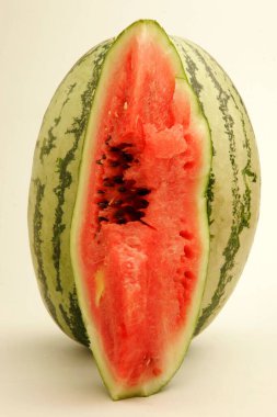 Fruits ; One half cut watermelon showing inside red watery pulp with black seeds ; Pune ;  Maharashtra ; India clipart