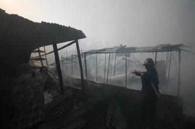 Versova 'daki Mhada kolonisinde patlak veren yangını söndürmeye çalışan itfaiyeci; Andheri; Bombay şimdi Mumbai; Maharashtra; Hindistan