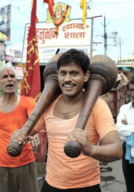 Janmashtami festivali ya da Lord Krishna doğum günü karnavalı adamı Jabalpur 'da ağır ahşap halterlerle gücünü gösterdikten sonra mutlu ve gururlu hissediyor; Madhya Pradesh; 