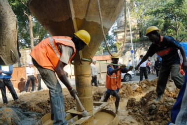 İşçiler, Dr. Ambedkar yolu, Bombay Bombası, Maharashtra, Hindistan 'da 24 Km uzunluğunda Lalbaug üstgeçidi için beton dolduruyor. 