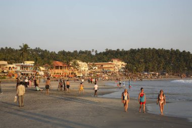 Tourists on Kovalam beach in evening, Thiruvananthapuram District, Kerala, India  clipart