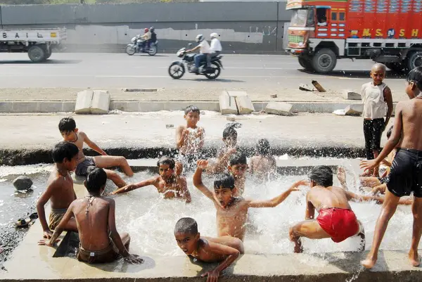 Çocuklar yaz sıcağını yenmek için su tankında oynuyorlar, Bombay şimdi Mumbai, Maharashtra, Hindistan  