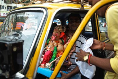 Devotees carrying lord ganesh idol in taxi on ganpati festival, Lalbaug, Bombay Mumbai, Maharashtra, India 22-August-2009  clipart
