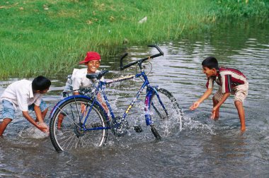 South Asian Indian boys washing bicycle   clipart