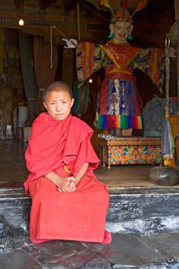 Tikse Budist Manastırı 'nın, Ladakh' ın, Jammu 'nun ve Kaşmir' in tapınak kapısında oturan kırmızı cüppeli genç bir lama. 