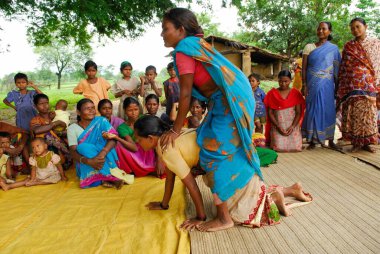 Ho kabilelerinden kadınlar sırtına biniyor ve tıbbi bilgileri paylaşıyorlar, Chakradharpur, Jharkhand, Hindistan  